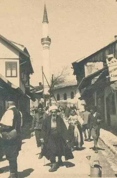 Prolaznici u staroj ulici ispod munare, stara fotografija