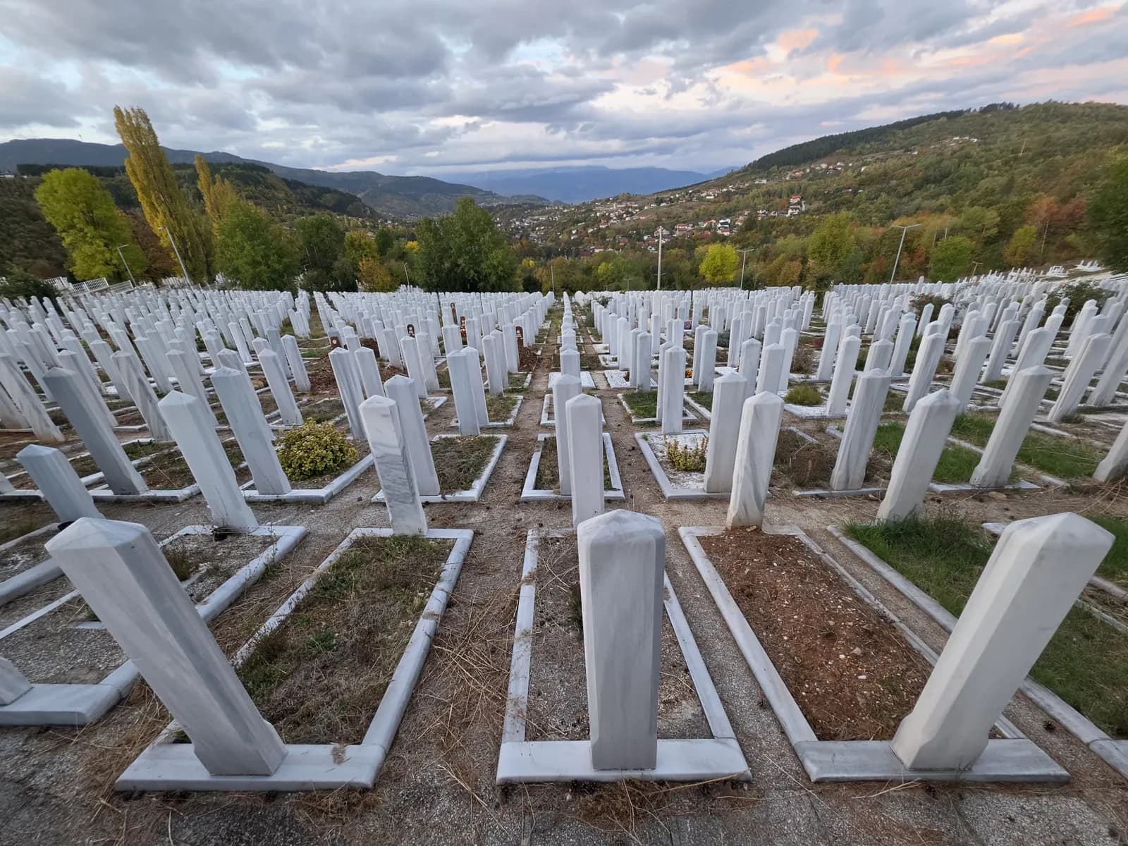Redovi bijelih nišana na mezaristanu Faletići pod oblačnim nebom